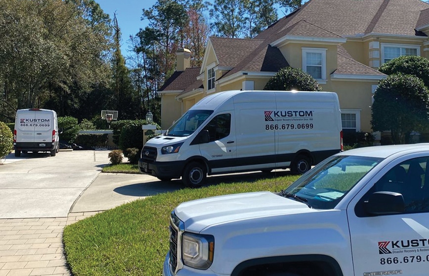 Kustom Disaster Restoration vehicles parked onsite at a residential home for a water damage loss